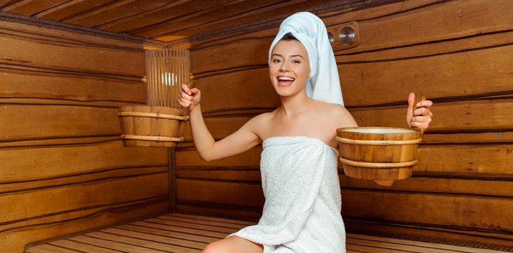 smiling-and-attractive-woman-in-towels-holding-washtubs-in-sauna-2